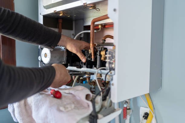 A technician is fixing a gas boiler, identified as 'Air Handler,' in a domestic setting.