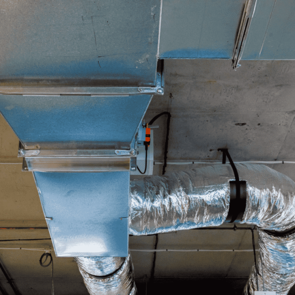 A blue pipe featuring a metal cover, integrated into a duct system, highlighting its functional purpose.