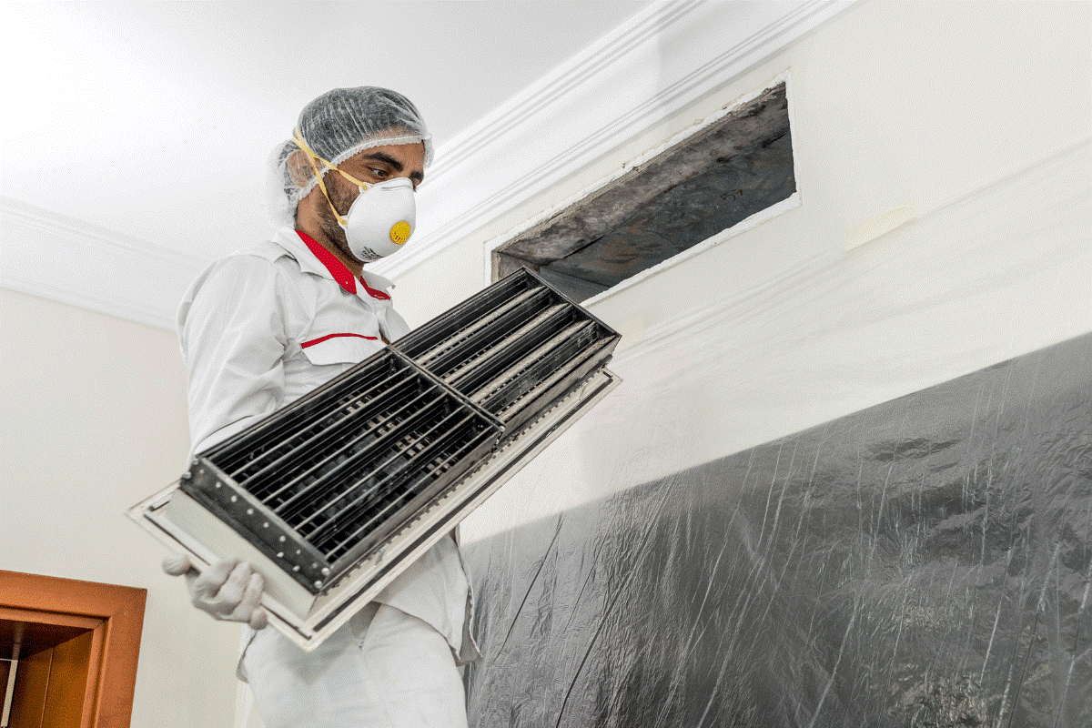 Technician inspecting dirty coils before AC coil cleaning service