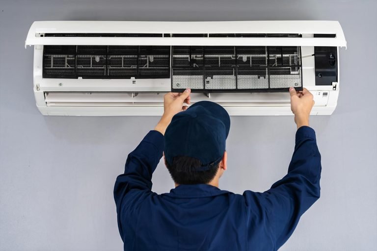 An AC repairing technician working on indoor unit of the air conditioner