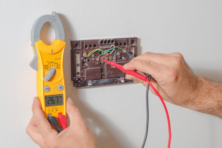 Technician handling smart thermostat installation and repair with wiring inside house