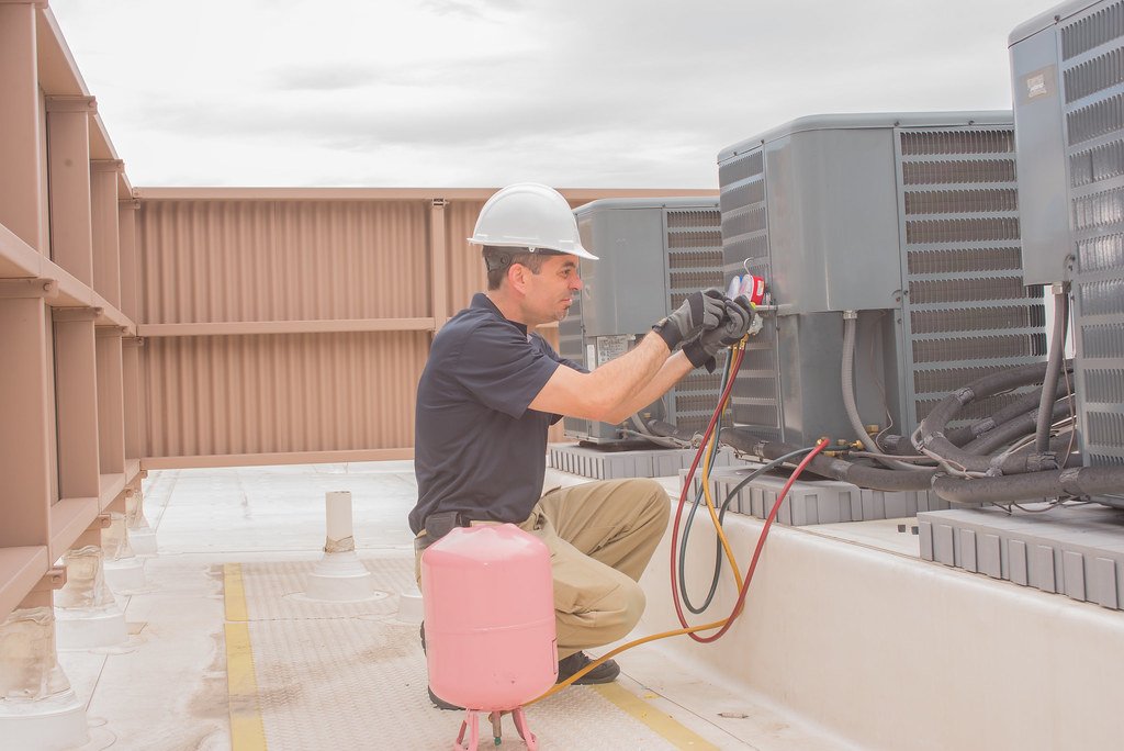 Air conditioning contractor installing residential AC unit