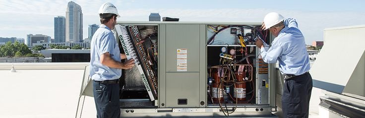 Technician inspecting unit during preventive HVAC maintenance service