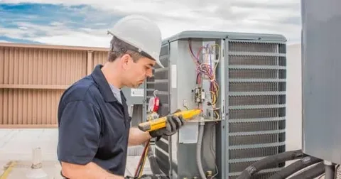 HVAC technician cleaning coils during preventive HVAC maintenance service