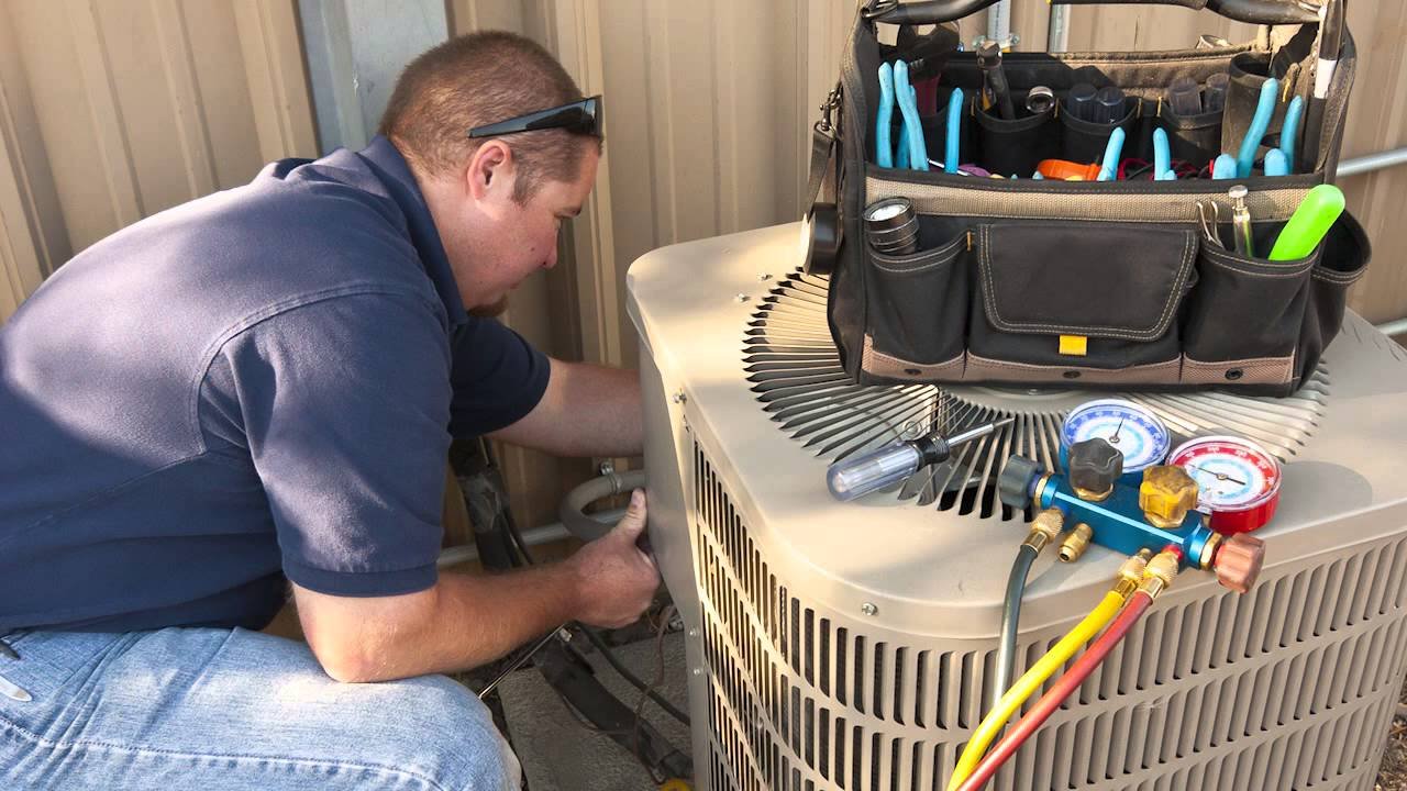Technician providing emergency AC repair service for a broken air conditioner